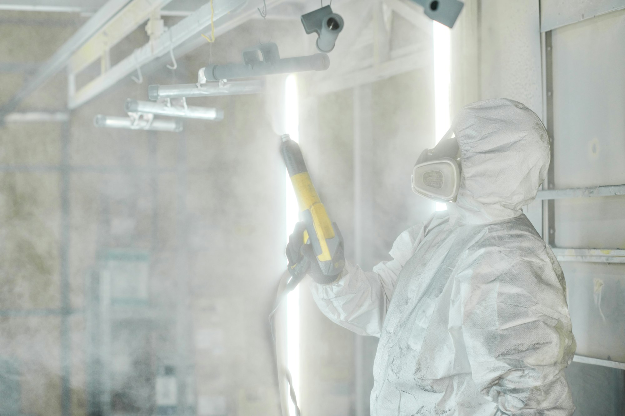 Worker in protective suit painting details